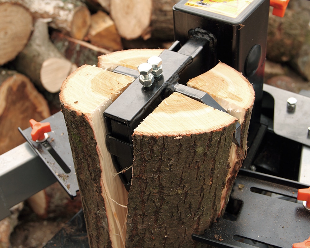 Ein hydraulischer Holzspalter mit 4-facht Spaltkreuz spaltet einen Holzklotz